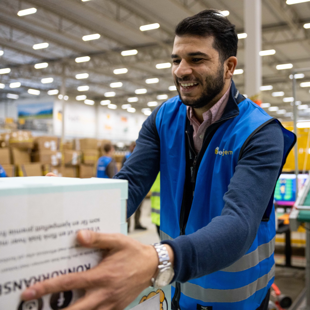 Smilender arbeider på lager